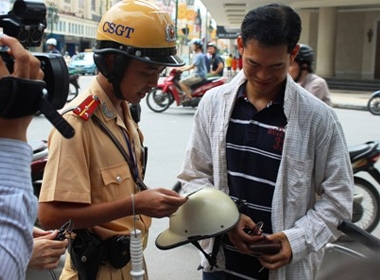 Phạt người đội mũ bảo hiểm rởm: CSGT hướng dẫn người tham gia giao thông về cách phân biệt mũ giả.