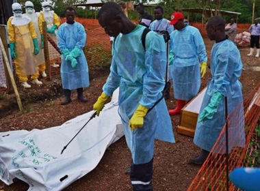 Nhân viên y tế phun thuốc lên thi thể nạn nhân Ebola tại Sierra Leone.