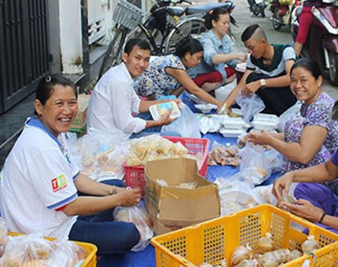 Chị Lan (trái) và mọi người đang tất bật chuẩn bị cơm cho bệnh nhân nghèo. 