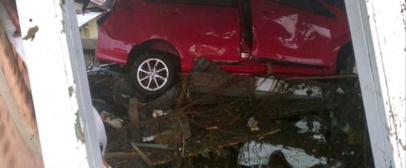 Một xe hơi bị sóng thần cuốn kẹt vào một ngôi nhà bị động đất đánh sập ở Palu, tỉnh Trung Sulawesi (Indonesia). Ảnh: AP chụp ngày 29-9
